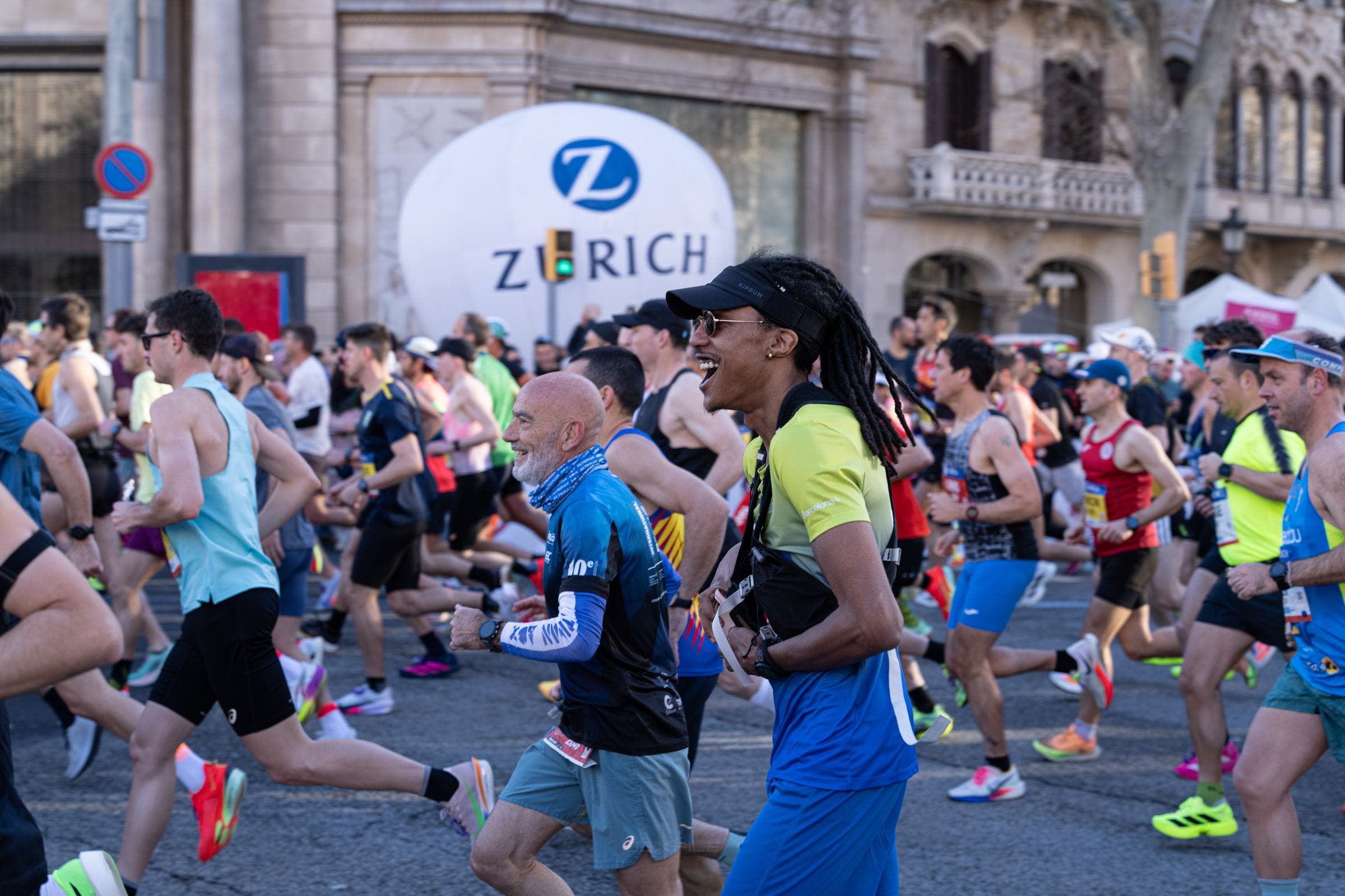 Smiling runners mid-race on Passeig de Gràcia during the Barcelona Marathon