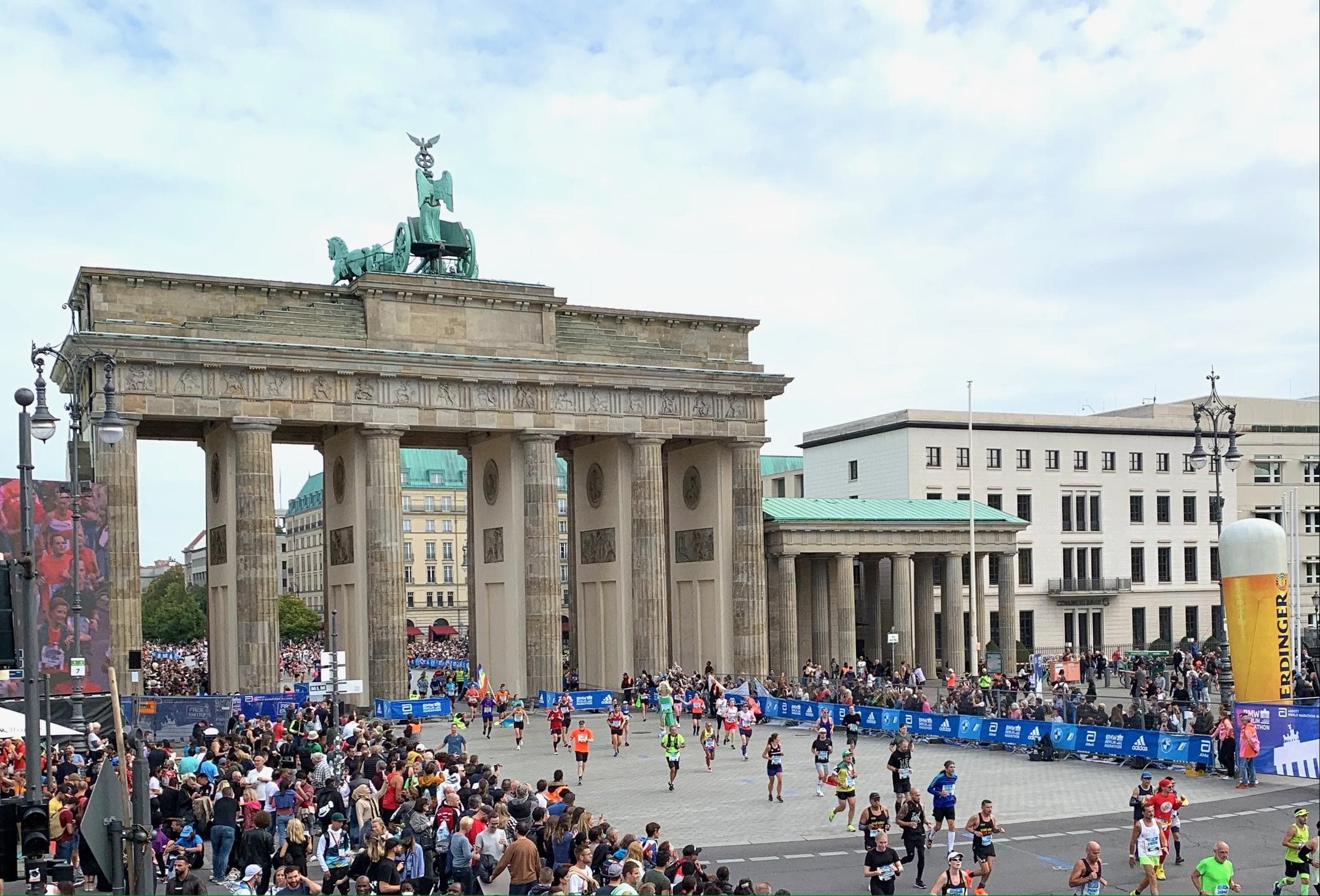 Runners streaming past the Brandenburg Gate towards the Berlin Marathon finish