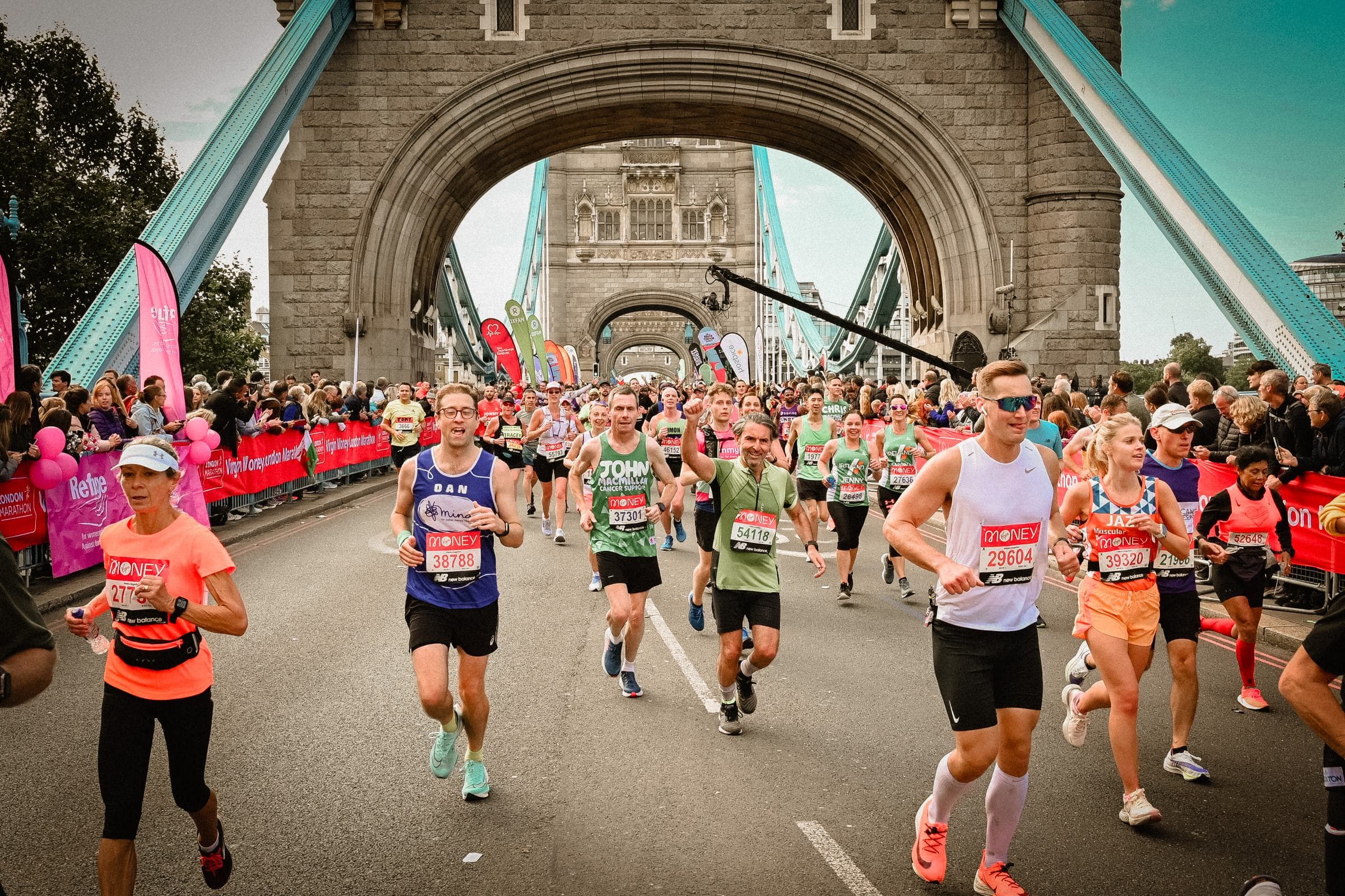 Runners crossing Tower Bridge among cheering crowds at the London Marathon