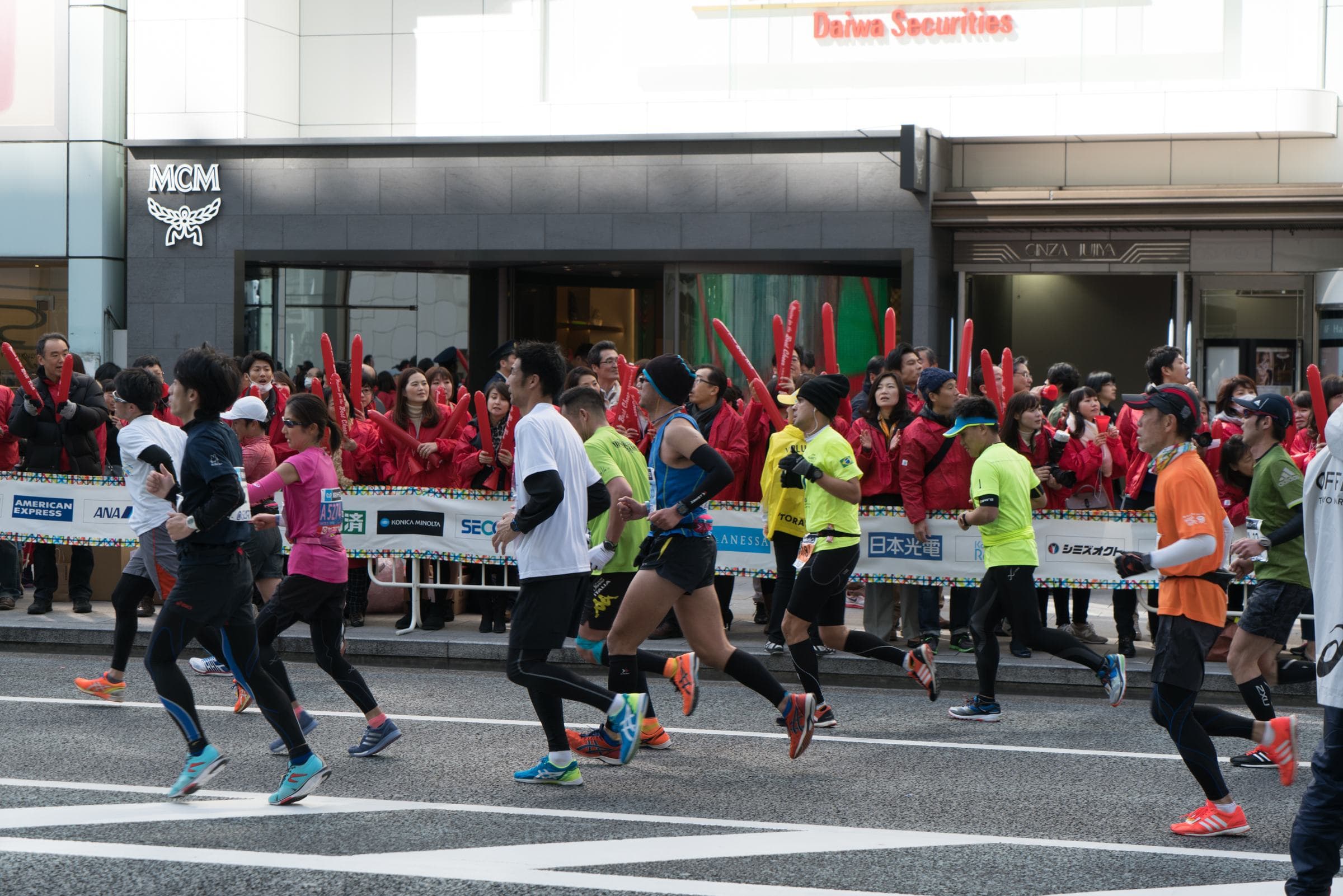 Tokyo Marathon runners passing cheering spectators on Ginza's main street